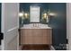 Chic powder room featuring stylish vanity, a sleek mirror, designer lighting, and elegant fixtures at 1214 S Kings Dr # A, Charlotte, NC 28207
