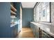 A stylish butler's pantry with custom blue cabinets, floating wood shelves, and elegant marble countertops at 1214 S Kings Dr # A, Charlotte, NC 28207