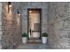 Inviting front entry with brick walls, potted greenery, and a view into the home at 1214 S Kings Dr # A, Charlotte, NC 28207