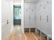Hallway with custom cabinets and storage seating, featuring beautiful hardwood floors and a view to a window at 1214 S Kings Dr # A, Charlotte, NC 28207