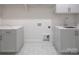 Bright laundry room features white cabinetry, quartz countertops, and modern hexagon tile flooring at 1214 S Kings Dr # A, Charlotte, NC 28207