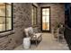 Cozy brick patio featuring cushioned seating, a small table, and view into the home's interior at 1214 S Kings Dr # A, Charlotte, NC 28207