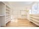 Spacious walk-in closet with custom shelves and hardwood floors at 1214 S Kings Dr # A, Charlotte, NC 28207