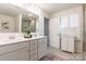Bright bathroom features double sinks, white cabinetry, and a window for natural light at 14450 Maritime Dr, Lancaster, SC 29720