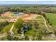 Wide aerial shot of the property featuring a pond, surrounding fields, and a home with lush landscaping at 1565 Shinnville Rd, Cleveland, NC 27013