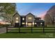 Stunning stone and black home with lush lawn, fenced yard, and a private driveway showcasing curb appeal at 1565 Shinnville Rd, Cleveland, NC 27013
