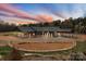 Stunning home with a dusk sky, stone accents, covered parking, a horseshoe drive, and lush landscaping at 1565 Shinnville Rd, Cleveland, NC 27013