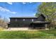 Exterior shot of black home with outdoor patio, well-manicured lawn, and private, fenced yard at 1565 Shinnville Rd, Cleveland, NC 27013