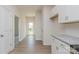 Bright hallway featuring hardwood floors and white trim, leading to a glass door with backyard view at 1630 Troon Dr, Salisbury, NC 28144