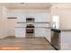 Modern kitchen featuring white cabinets, stainless steel appliances, granite countertops, and wood-look flooring at 1630 Troon Dr, Salisbury, NC 28144