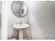 Modern powder room with pedestal sink and circular mirror at 202 Brentwood Dr, Statesville, NC 28625