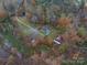 Aerial view of the home nestled amongst the fall foliage with a long drive and a small pond at 2073 Mauney Rd, Bessemer City, NC 28016