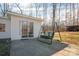 Backyard of this cozy home, featuring a patio swing and a storage shed surrounded by mature trees at 2073 Mauney Rd, Bessemer City, NC 28016