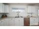 Kitchen counter featuring white cabinets, stainless steel appliances, and a view out the window at 2073 Mauney Rd, Bessemer City, NC 28016