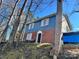 Brick and blue-sided house with a steeply sloped yard at 323 Whispering Pines Dr, Charlotte, NC 28217