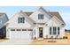 White two-story house with gray shutters, a two-car garage, and landscaping at 4219 Moxie Way, Charlotte, NC 28215