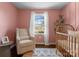 Charming Bedroom features a comfy chair, crib, and natural light at 4554 Crestmont Dr, Charlotte, NC 28205