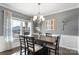 Dining room with hardwood floors, chandelier, gray walls, and a large window at 5055 Stonehill Ln, Matthews, NC 28104