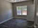 A bedroom with fresh paint, vinyl floors, an open closet, and a window overlooking the front yard at 609 Shiloh Unity Rd, Lancaster, SC 29720