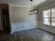 Dining room featuring classic wainscoting, a modern chandelier, and a large window for ample natural light at 609 Shiloh Unity Rd, Lancaster, SC 29720