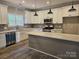Modern kitchen featuring stainless steel appliances, white cabinets, and an island with quartz countertops at 609 Shiloh Unity Rd, Lancaster, SC 29720