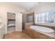 Relaxing bathroom with a soaking tub, glass enclosed shower, tile floor and access to the main bedroom at 6411 Aldworth Ln, Charlotte, NC 28226