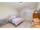 Cozy bedroom with pink metal bed frame, large window with blinds, and charming decor at 6411 Aldworth Ln, Charlotte, NC 28226