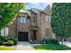 Beautiful brick townhome with an attached garage, manicured front lawn, and a peaked roof at 6411 Aldworth Ln, Charlotte, NC 28226