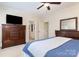 Spacious main bedroom with ceiling fan, TV, large dresser and access to the en-suite bathroom at 6411 Aldworth Ln, Charlotte, NC 28226