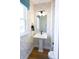 Stylish powder room with pedestal sink, geometric wallpaper, and modern fixtures at 8052 Cedarsmith Ct, Charlotte, NC 28217