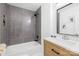 Bathroom with grey tile, a shower/tub combo, and a light wood vanity at 1001 Archdale Dr, Charlotte, NC 28217