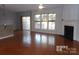 Spacious living room with hardwood floors, fireplace, and large windows at 10244 Blakeney Preserve Dr, Charlotte, NC 28277