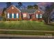 Brick ranch home with landscaped lawn and blue shutters at 1117 Butterburr Dr, Matthews, NC 28104