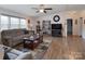 Spacious living room featuring hardwood floors, a comfy sofa, and a large TV at 115 Tradewinds Ct, Mooresville, NC 28115