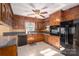 Kitchen with wood cabinets, granite counters, and black appliances at 133 Devine St, Stanley, NC 28164