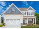 Two-story house with beige siding, white garage door, and stone accents at 1420 Nia Rd, Charlotte, NC 28215