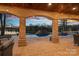 Relaxing patio area with pool and lake views; brick columns and string lights at 19107 Wildcat Trl, Davidson, NC 28036