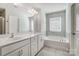 Elegant bathroom with double sinks, a bathtub and marble flooring at 19117 Hawk Haven Ln, Charlotte, NC 28278