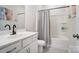 Clean bathroom with white vanity, tub, and gray shower curtain at 19117 Hawk Haven Ln, Charlotte, NC 28278