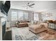 Spacious living room with L-shaped sofa, fireplace, and ceiling fan at 19117 Hawk Haven Ln, Charlotte, NC 28278