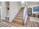 Carpeted staircase with white spindles and views of the home office and entryway at 19117 Hawk Haven Ln, Charlotte, NC 28278