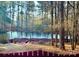 Partially frozen pond with wooded backdrop and red fence at 2044 Standing Timber Rd, Lancaster, SC 29720