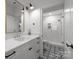 Modern bathroom with white vanity, black accents, and geometric floor tiles at 2130 Ferncliff Rd, Charlotte, NC 28211