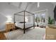 Main bedroom with four-poster bed, sitting area, and large windows at 2130 Ferncliff Rd, Charlotte, NC 28211