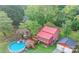 An aerial view of a charming home with a red roof, surrounded by lush greenery and a sparkling blue pool at 2407 Brookside Ave, Kannapolis, NC 28081