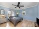 Cozy bedroom with light blue walls, wood floors, natural lighting, and a ceiling fan at 2407 Brookside Ave, Kannapolis, NC 28081