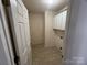 Bright laundry room with tile floor, cabinets, and door to hallway at 2509 Calgary Pl, Concord, NC 28027