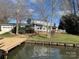 Lakefront home with deck and dock; lush landscaping at 273 Leeward Point Loop, Taylorsville, NC 28681