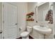 Chic powder room features a pedestal sink, decorative mirror, and dark wood floors at 273 Sweet Briar Dr, Fort Mill, SC 29707