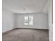 Bedroom featuring painted wood paneled walls, neutral carpet, and natural light from double windows at 34 Lee Rd, Stony Point, NC 28678